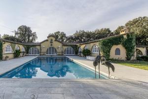 an estate with a swimming pool with two birds standing next to it at Masia Mimosa Jardin in Darnius
