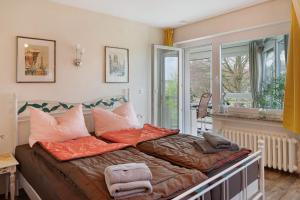 a couch with pillows on it in a room with windows at Wintergarten Am Thingplatz in Rinteln