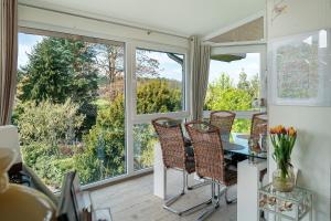 a screened in porch with a table and chairs and windows at Wintergarten Am Thingplatz in Rinteln