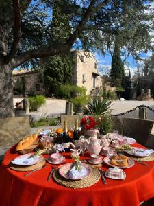 a table with a red table cloth with food on it at Masia Mimosa Jardin in Darnius