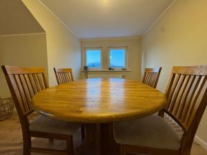 a dining room with a wooden table and chairs at Apartment Oben in der Heide in Faßberg
