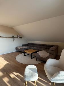 a living room with a couch and a table and chairs at Apartment Oben in der Heide in Faßberg +2 photos