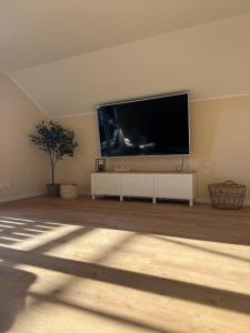 a living room with a large flat screen tv on a wall at Apartment Oben in der Heide in Faßberg
