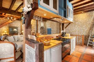 a kitchen with a stove top oven next to a living room at Maison historique en pierre in Issigeac