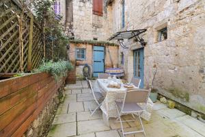 a patio with a table and chairs in an alley at Maison historique en pierre in Issigeac