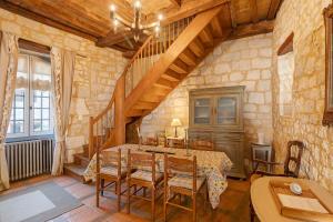 a dining room with a table and a staircase at Maison historique en pierre in Issigeac +20 photos