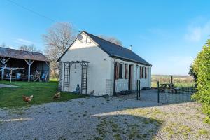 a small white building with chickens outside of it at Gîte Chemin Des Hêtres in Armaillé +24 photos