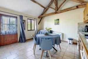 a kitchen with a table and chairs in a room at Gîte Chemin Des Hêtres in Armaillé