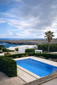 a swimming pool with a view of the ocean at Duplex Laura in Es Mercadal