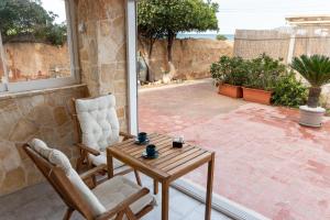 a patio with two chairs and a wooden table at La Porta Sul Mare- Timone in Mola di Bari