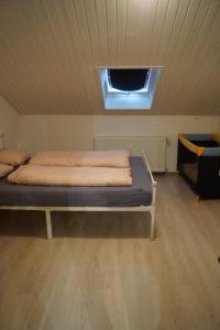a bed in a room with a ceiling with a window at Quiet And Renovated Apartment in Schwendi