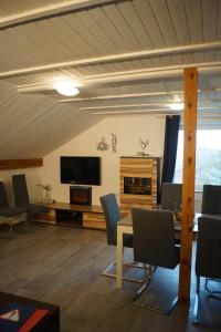 a living room with a table and chairs and a television at Quiet And Renovated Apartment in Schwendi