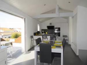a kitchen and living room with a table and chairs at La Maison Du Marché - Balcon in La Tranche-sur-Mer