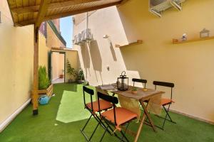 a room with a table and chairs on a green floor at Colina Verde Maspalomas in Maspalomas