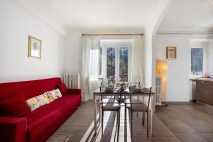 a living room with a red couch and a table at Casa Tua - Arvier in Arvier