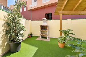an outdoor patio with green grass and plants at Colina Verde Maspalomas in Maspalomas