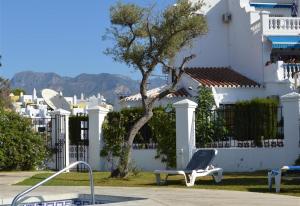 a chair sitting in front of a white house at Townhouse with Sea View in Nerja
