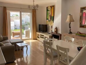 a living room with a couch and a table and chairs at Townhouse with Sea View in Nerja