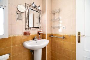a bathroom with a sink and a mirror at Apartamento Merce in Rota +17 photos