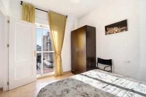 a bedroom with a bed and a large window at Apartamento Merce in Rota