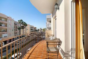 a balcony with a table and chairs looking out onto a street at Apartamento Merce in Rota