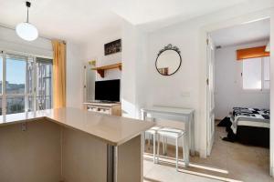 a kitchen and living room with a table and a television at Apartamento Merce in Rota