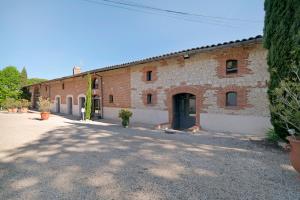 a large brick building with a driveway in front of it at Maison d'hôtes de Gailhaguet in Verfeil