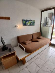 a living room with a couch and a table at Chez Colette du haut in Le Barcarès