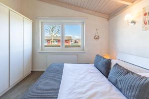 a bedroom with a large bed and a window at Ferienhaus Stockente in Dagebüll