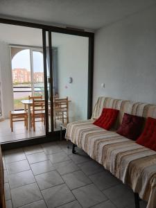 a bedroom with a bed and a balcony with a table at Chez Colette du haut in Le Barcarès +11 photos