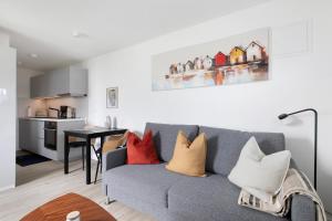a living room with a gray couch with colorful pillows at Ferienwohnung Emilia 2 in Garding