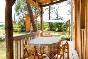 a table and chairs on the porch of a house at L'Escale du Dernier Pin in Escalans