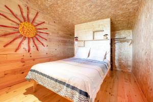 a bedroom with a bed in a wooden wall at L'Escale du Dernier Pin in Escalans