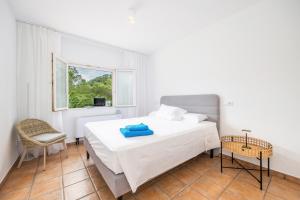 a white bedroom with a bed and a window at Villa Polina in Capdepera +34 photos