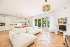a living room with a white couch and a kitchen at Villa Polina in Capdepera
