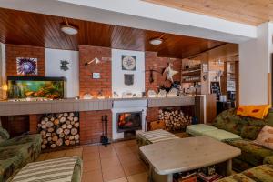 a living room with a brick fireplace and a tv at Penzion Tesák-ČERŇAVA in Chvalčov