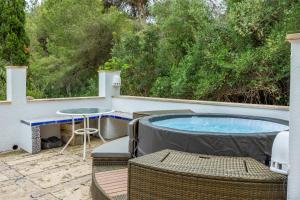 a hot tub on a patio with a table and chairs at Villa Polina in Capdepera