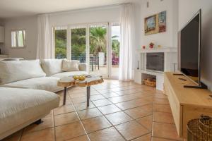 a living room with a couch and a tv at Villa Polina in Capdepera