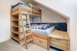 a bunk bed and a desk in a room at FeWo Am Pier 7a in Loddin