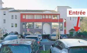 a parking lot with cars parked in front of a building at Studio Rénové - Le Verdale in Lamalou-les-Bains