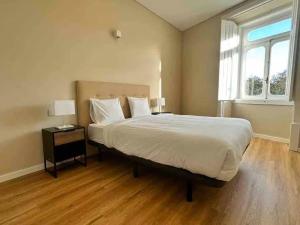 a bedroom with a large bed and a window at Setubal Prime, By Home Match in Setúbal