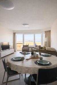 a living room with a table and a couch at Anna's Haven, Knokke in Knokke-Heist