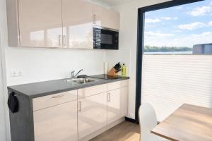 a kitchen with a sink and a table and a window at Floatinghouse Bakerman in Zehdenick +15 photos