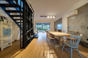 a dining room with a table and chairs and a staircase at Blue Pine Villa in Marathon