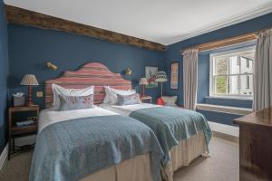 a bedroom with two beds with blue walls at The King's Arms in Hawkshead