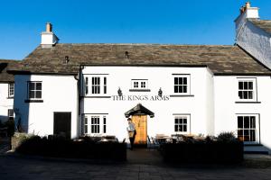 a man standing in front of a white building at The King's Arms in Hawkshead