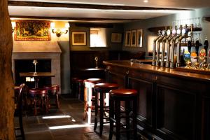 a bar with bar stools and bottles of wine at The King's Arms in Hawkshead +45 photos