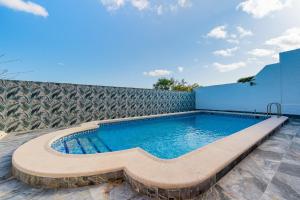 a swimming pool with a bench in front of a building at Chalet del Lago in Torrevieja
