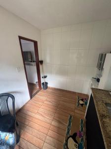 a room with a kitchen with a wooden floor at Família Ebeneze in Santa Maria Madalena