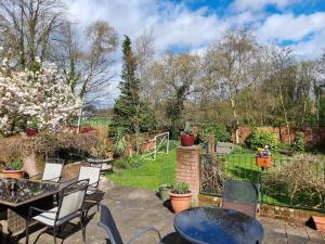 a patio with tables and chairs in a garden at Westbourne Lodge Birmingham in Birmingham